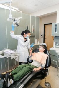 A dentist, Dr. Yamaguchi, with a child in a chair, Routine Dental Exams and Cleanings with Holistic Dentistry
